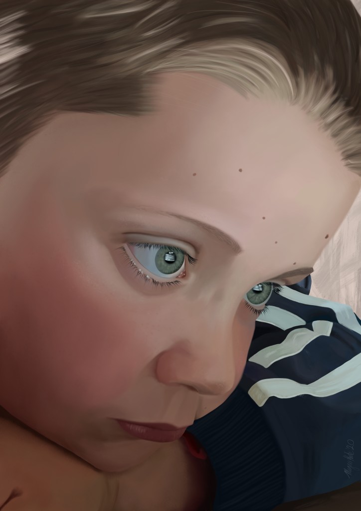 Close up of young boy resting chin on hand.